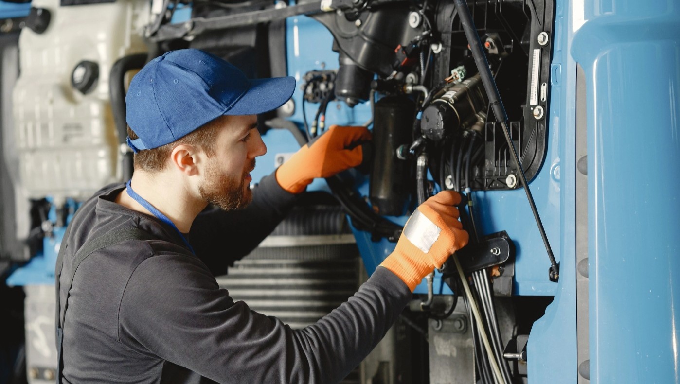 Homme en uniforme opérant avec des outils sur un camion électrique